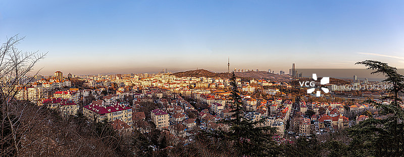 在信号山顶俯瞰夕阳下的青岛天际线全景，新老城区海岸线尽收眼底图片素材