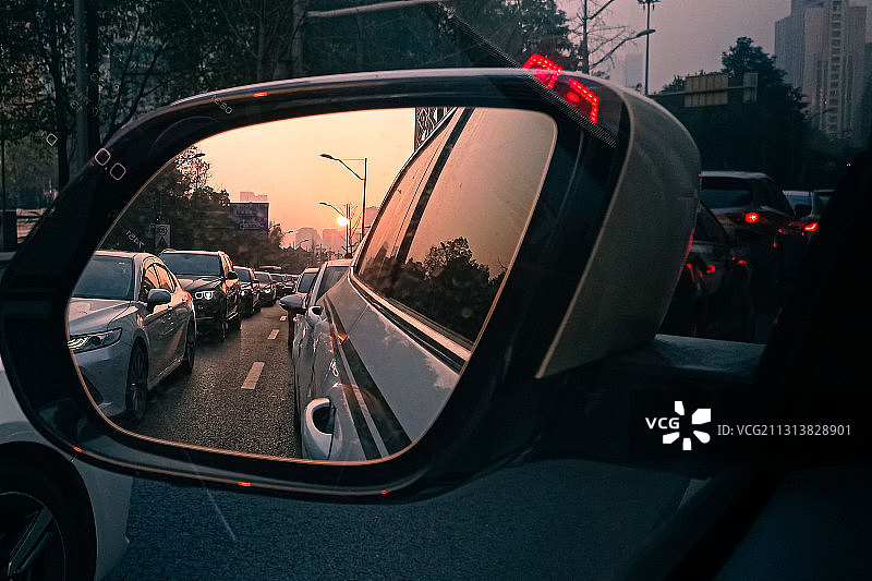 清晨，初升的阳光照亮后视镜中的车流，形成漂亮的冷暖对比图片素材