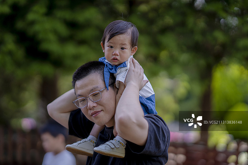 爸爸驮着婴儿逛公园图片素材