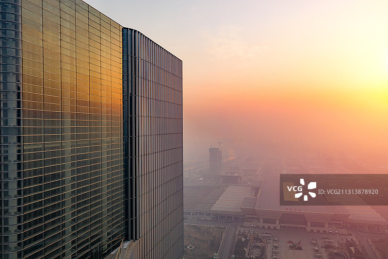 河南省郑州市郑东新区清晨日出时分写字楼郑州东站航拍高视角图片素材