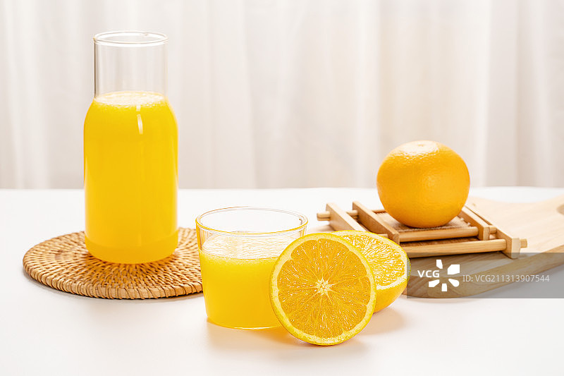 白色桌面上的橙汁和橙子图片素材