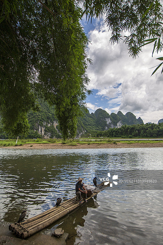中国广西桂林阳朔黄布倒影（渔翁、鱼鹰与江中倒影的和谐画面）图片素材