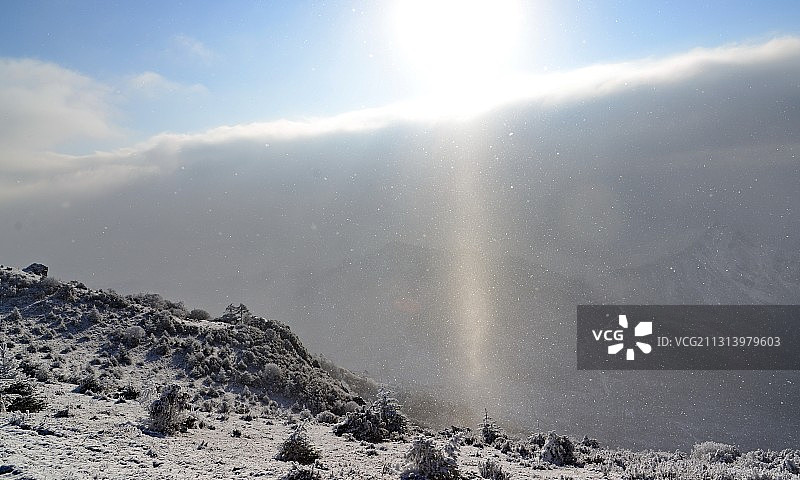 飘着雪花的早晨，太阳升起，穿透落雪，折射出奇异的光芒好似佛光图片素材