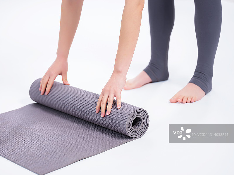 青年女子卷瑜伽垫图片素材