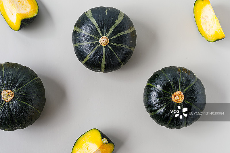 浅灰色背景上分散放着的绿色蔬菜贝贝南瓜图片素材