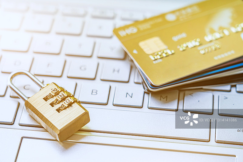 锁子和一叠信用卡放在笔记本键盘上图片素材