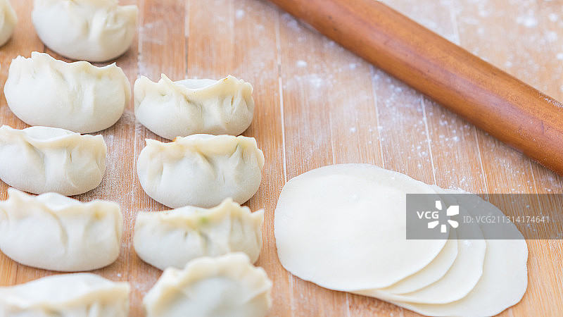 放在案板上的生饺子和饺子皮——饺子制作过程图片素材