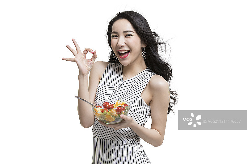 年轻时尚女性吃蔬菜沙拉图片素材