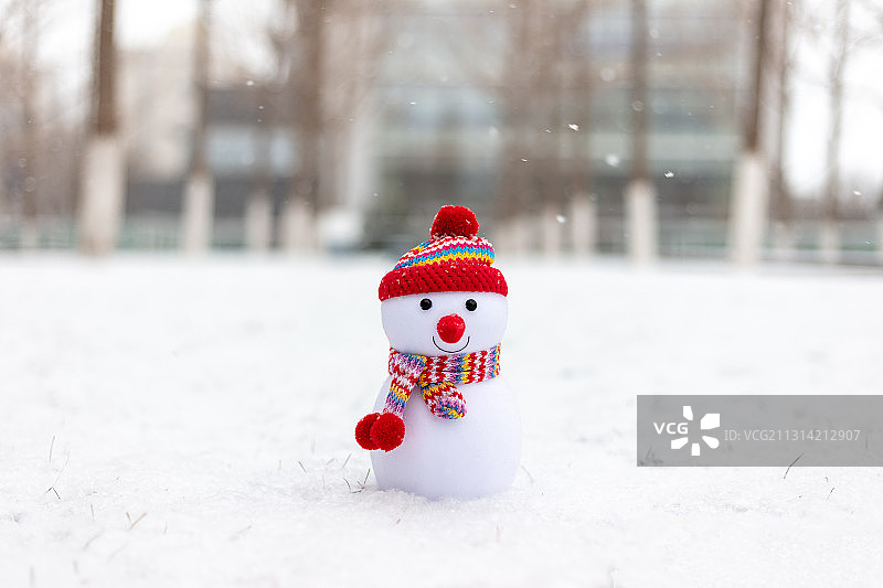 冰天雪地里戴红帽子围巾的小雪人图片素材