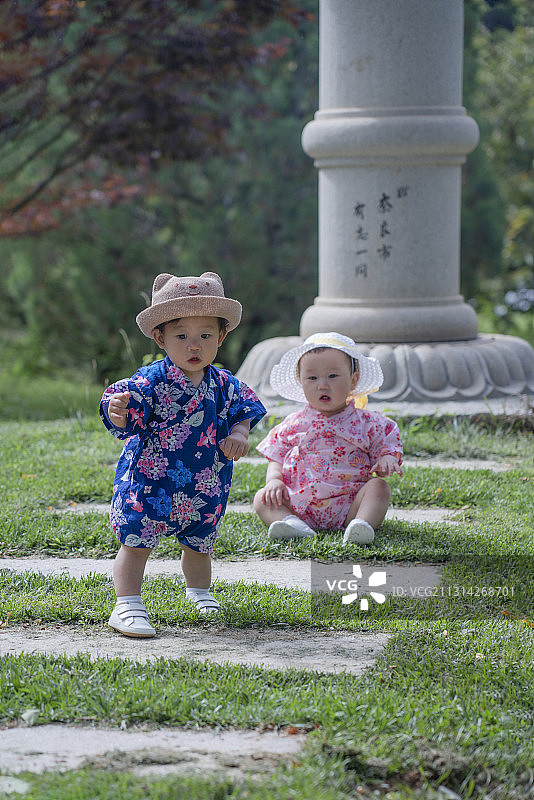 景区石塔石阶处两个快乐婴儿图片素材