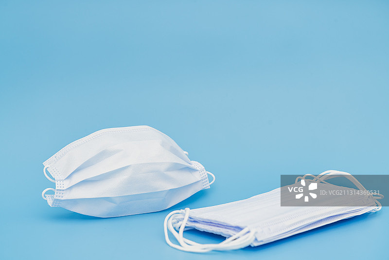 蓝色背景下的一次性医用口罩图片素材
