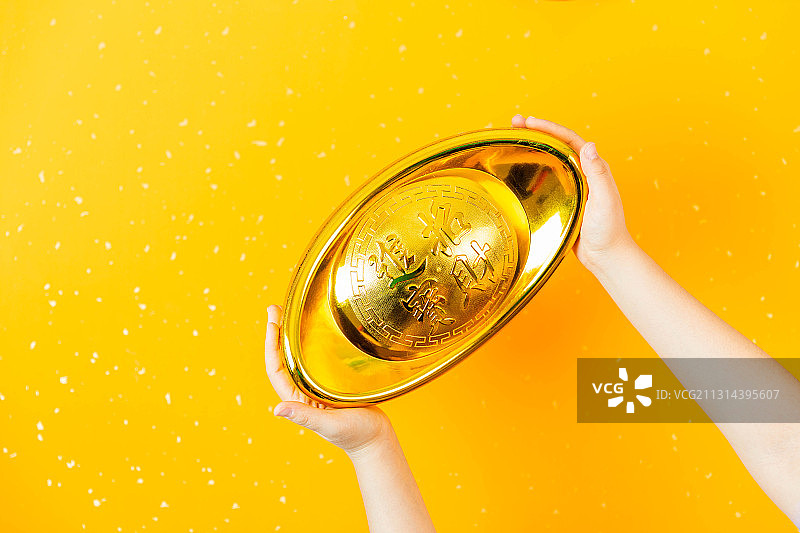 新年两只手拿着招财进宝金元宝图片素材