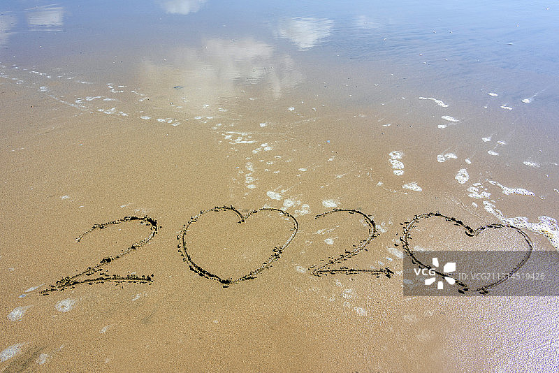 平静的海边沙滩上书写的数字2020图片素材