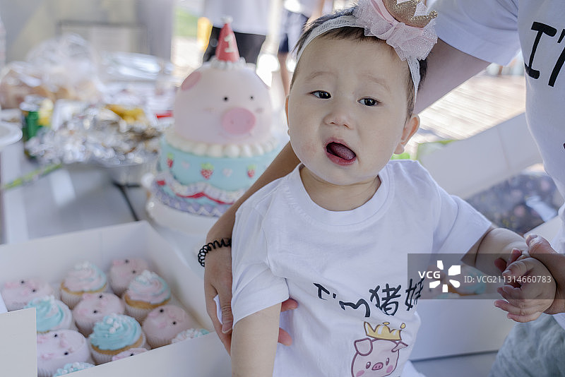 婴儿小寿星与她的生日蛋糕及冰激凌蛋筒图片素材