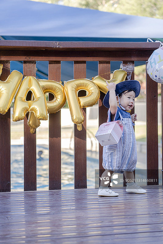 挎着礼盒去生日祝福的男婴图片素材