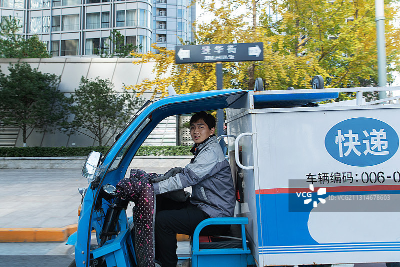 工作途中驾驶三轮车的快递员图片素材