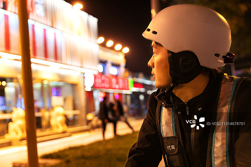 夜晚餐厅外等待订单的代驾员图片素材