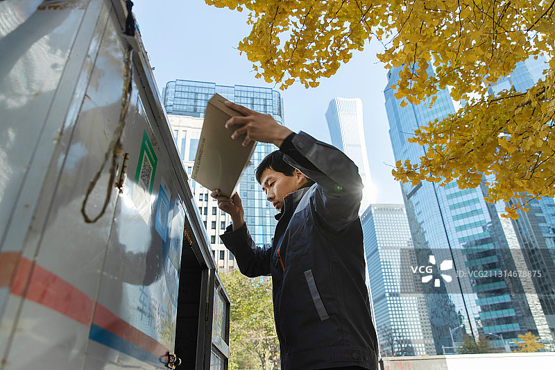 往车上装快递的快递员图片素材