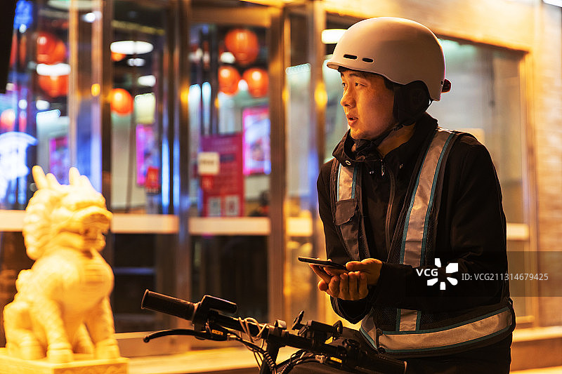 夜晚餐厅外等待订单的代驾员图片素材