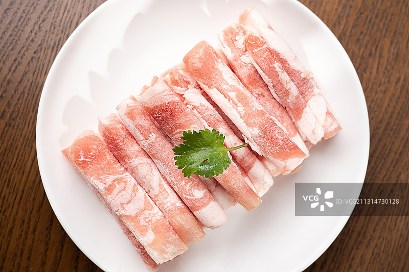 褐色木板上盘子里的鲜美肥羊肉卷图片素材