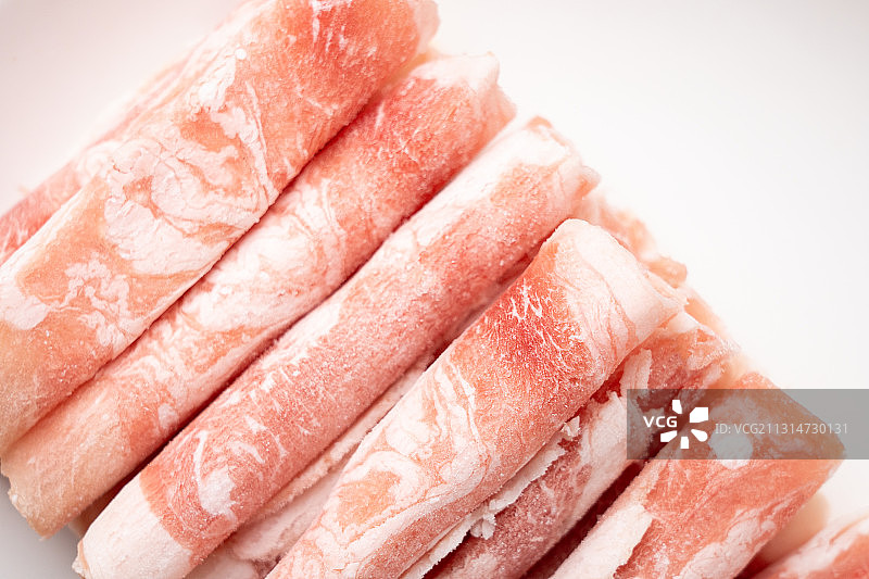 褐色木板上盘子里的鲜美肥羊肉卷图片素材