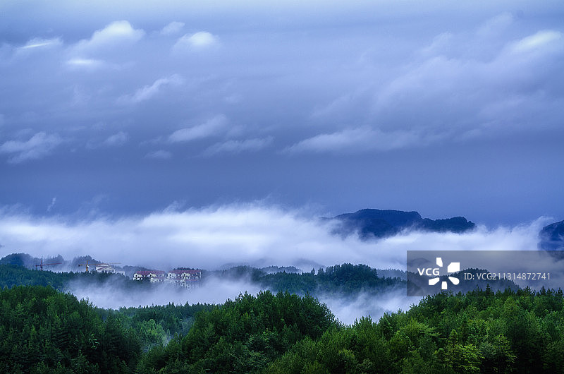 湖北利川，山中雨后云雾升腾，小小山村掩映其中。图片素材