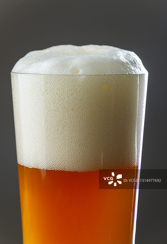 啤酒杯特写，灰色背景图片素材