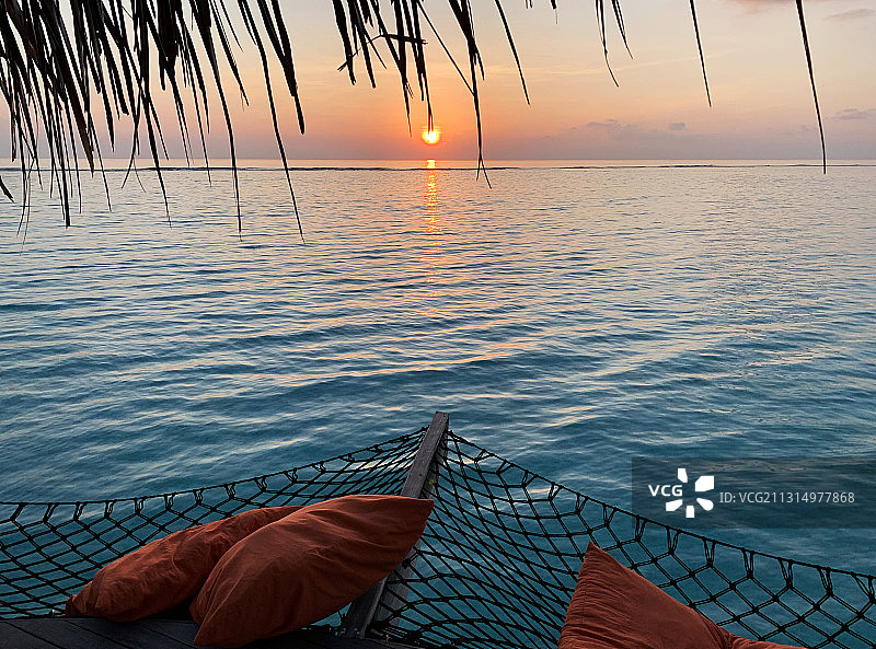 马尔代夫卡努呼拉日落时分，吊床悬挂在海面上图片素材