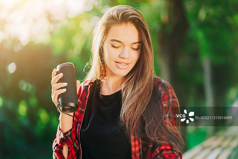 用无线便携式扬声器听音乐的现代潮流年轻女人图片素材