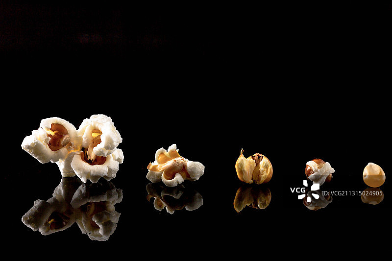黑色背景下不同爆裂阶段的爆米花图片素材