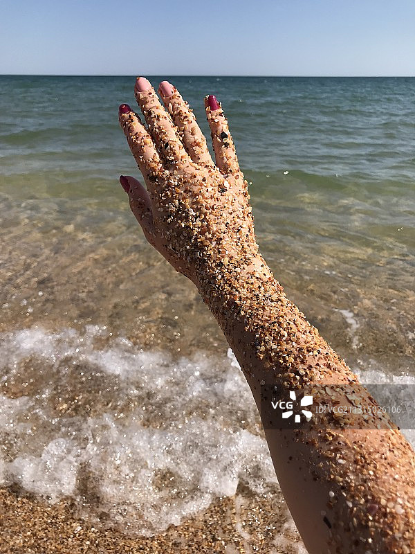 女子在沙滩上手臂的局部照片图片素材