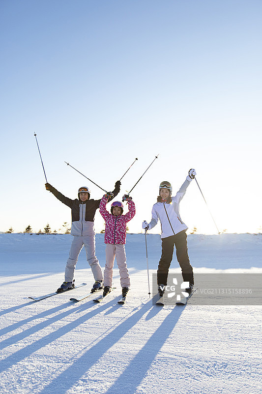 年轻家庭在滑雪场滑雪图片素材