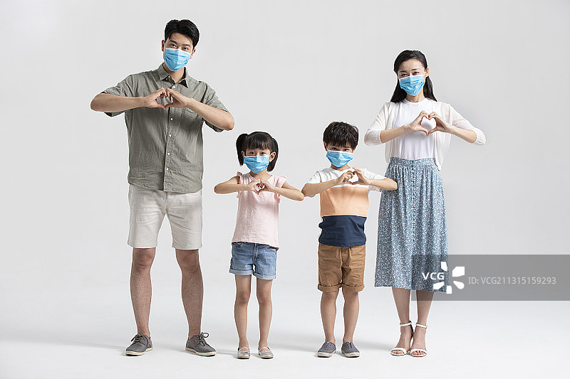 年轻家庭戴着口罩做心型手势图片素材