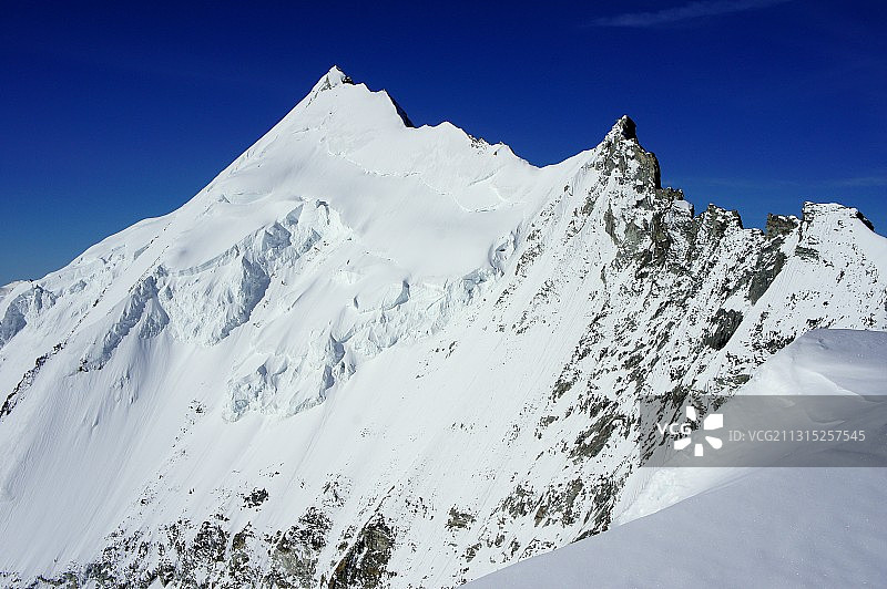瑞士上埃姆斯比什峰，蓝天下的雪山仰视角度图片素材