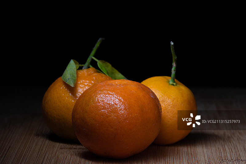 黑色背景下桌子上的橙子特写图片素材