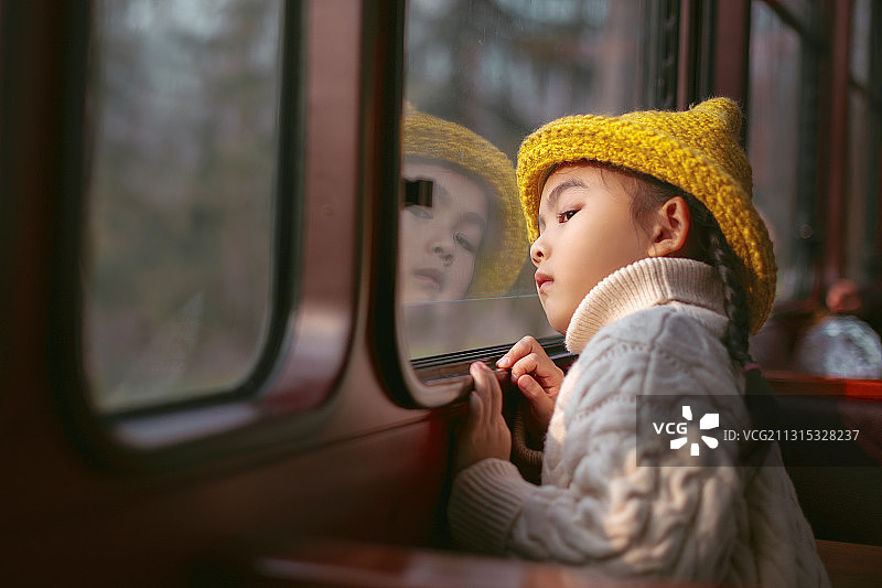 戴黄色帽子的小朋友坐火车看风景图片素材