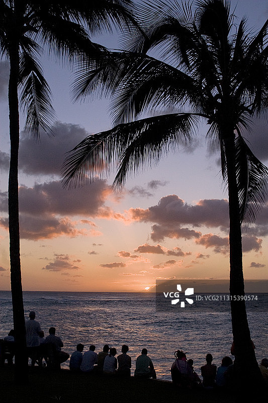 在海滩观看日落的游客图片素材