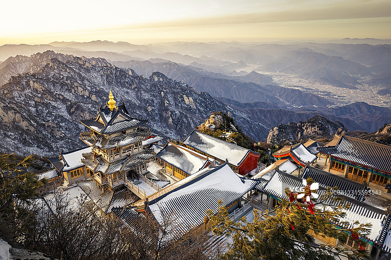 洛阳老君山的冬日傍晚，夕阳照耀下，山顶的道教建筑群分外美好图片素材