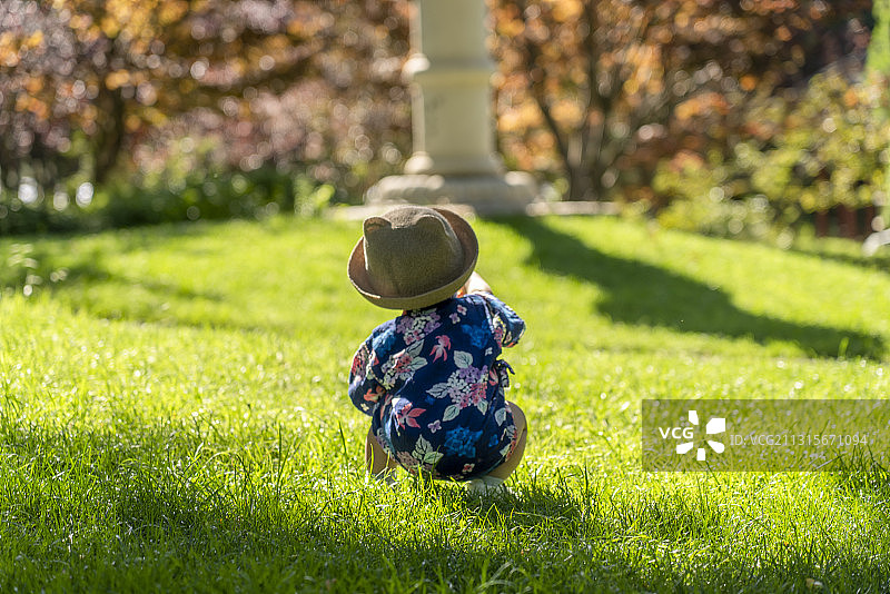 樱花石塔草坪处的男婴图片素材