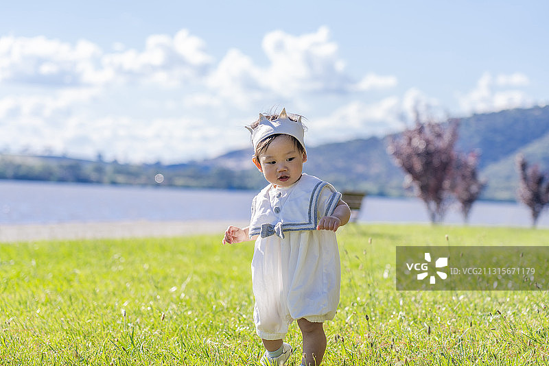 格里芬湖畔草坪上快乐奔跑的男婴图片素材