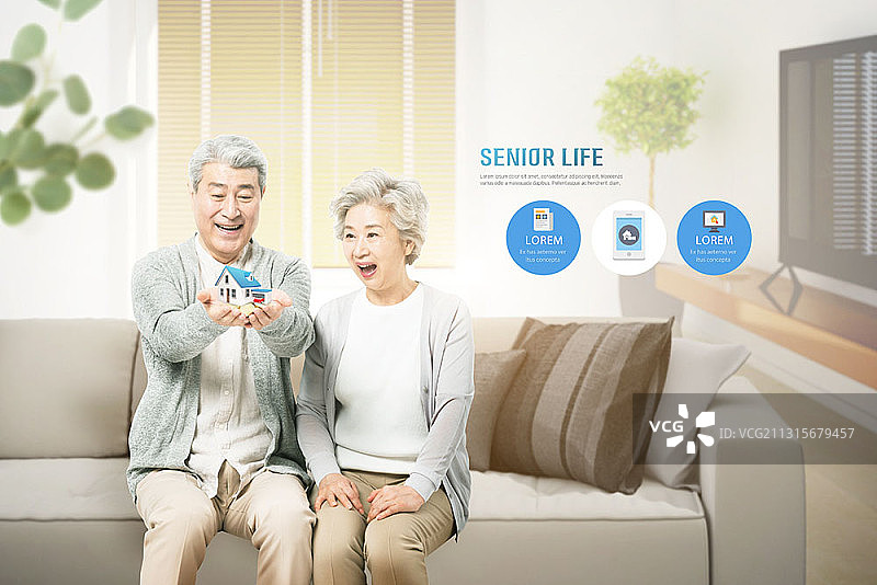 客厅里看房屋模型微笑的老年夫妇图片素材