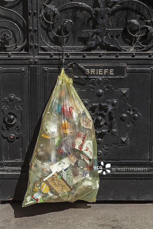 挂在前门上的黄色塑料垃圾袋，德国，欧洲图片素材