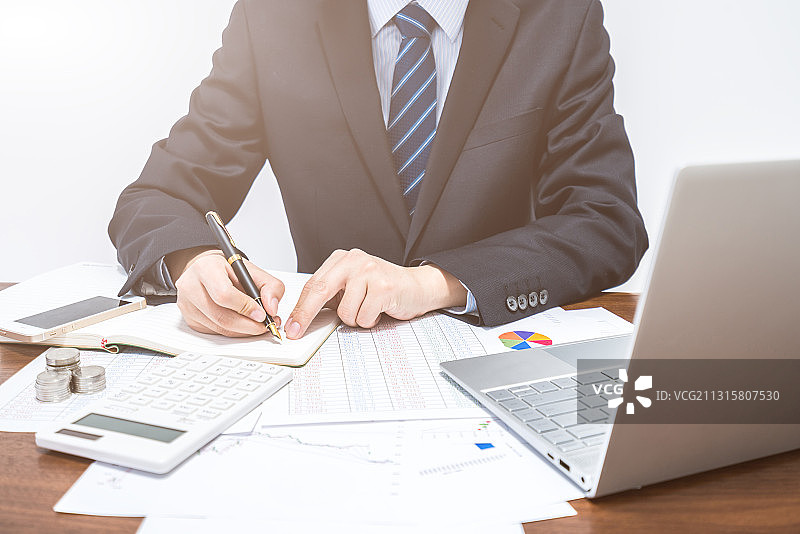 在笔记本上做记录的商人图片素材