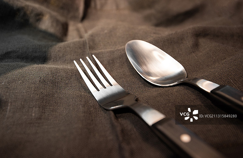 棚拍咖啡色桌布上刀叉餐具图片素材