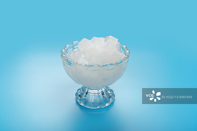 蓝色背景下高脚玻璃杯的椰肉图片素材