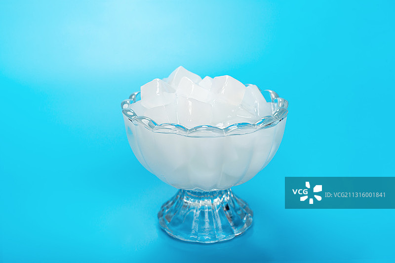 蓝色背景下高脚玻璃杯的椰肉图片素材