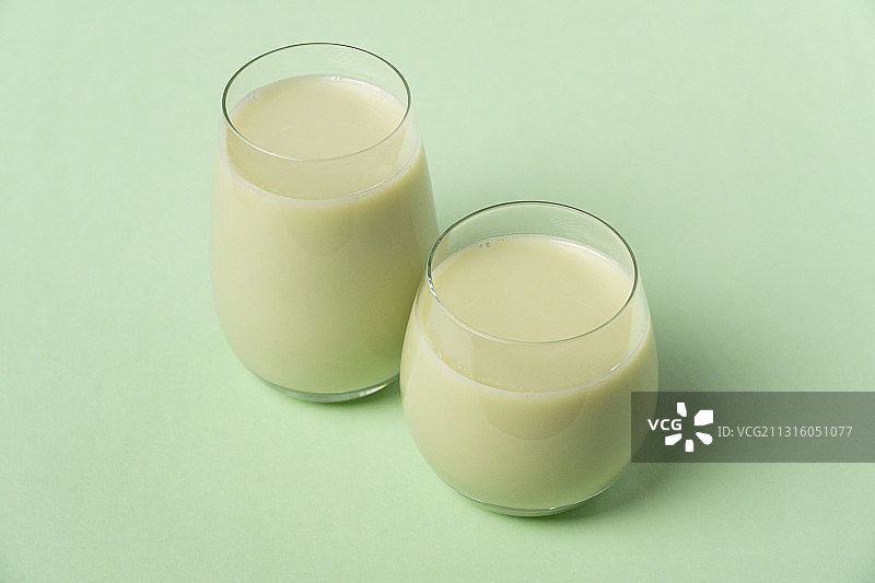 绿色纯色背景老北京地方传统美食杯子上的豆汁儿图片素材