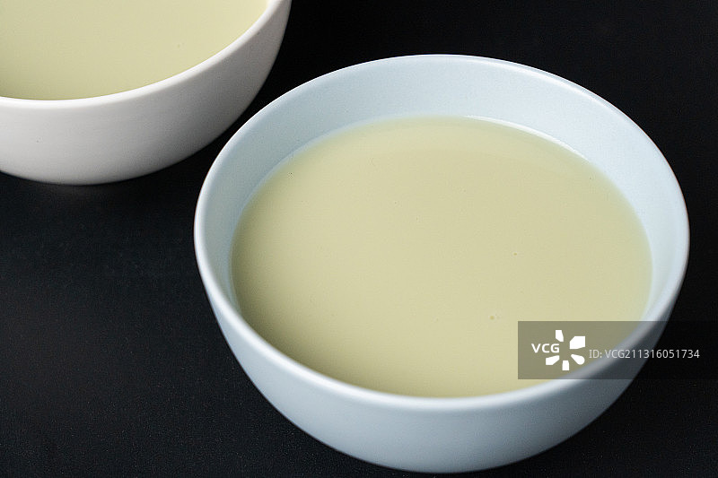 黑色留白棚拍中国首都北京传统碗上的小吃豆汁儿和绿豆图片素材