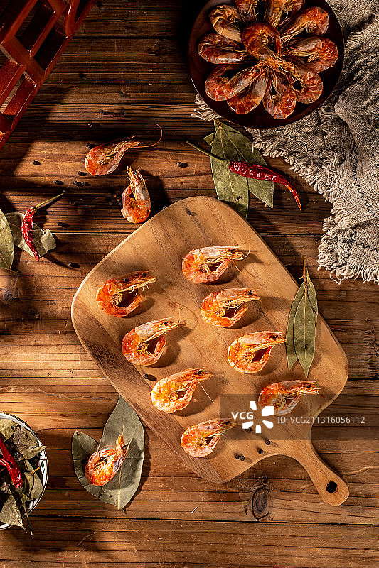 木板背景上铺着的干虾仁图片素材