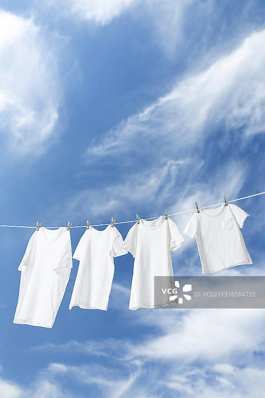 晾衣绳和天空上悬挂的白色T恤图片素材